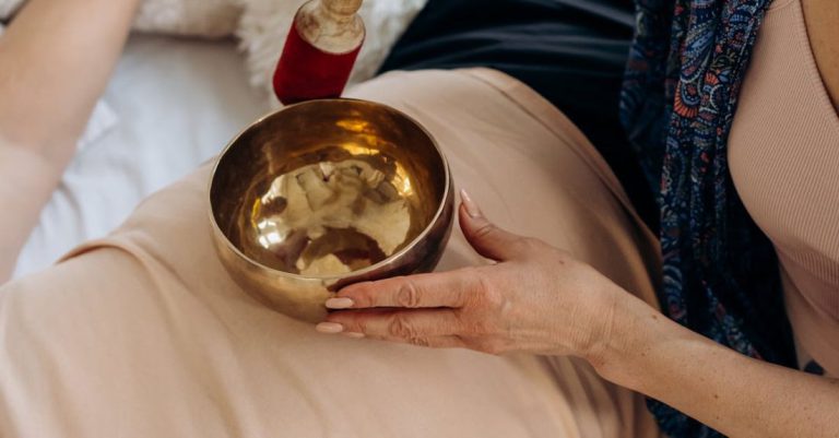 Ayurveda - Woman Holding Singing Bowl on Person's Stomach