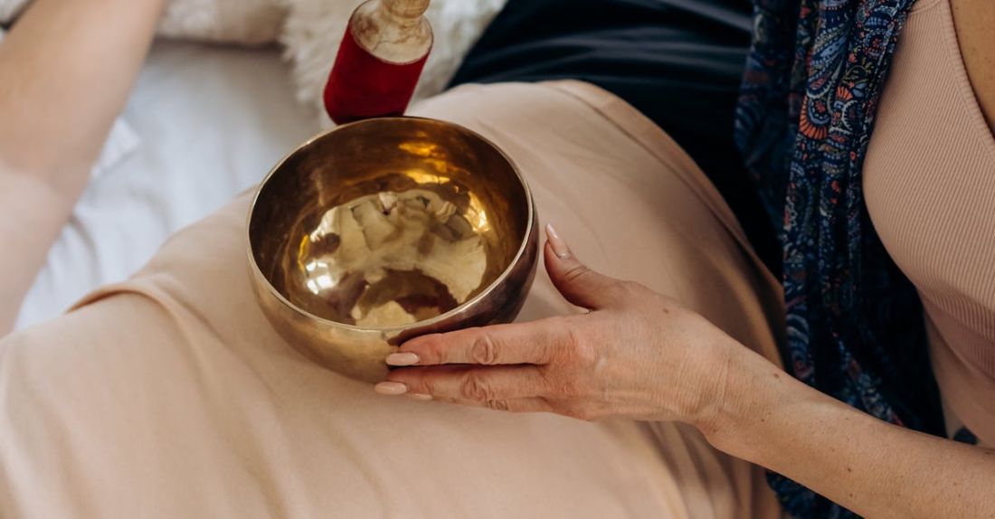 Ayurveda - Woman Holding Singing Bowl on Person's Stomach